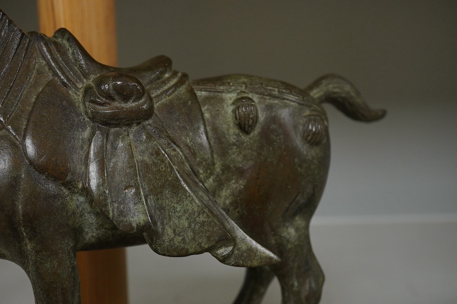 A Chinese bronze figure of a horse, Tang style, signed to the base, 24cm high. Condition - good